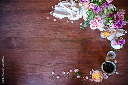 Flatlay of wooden table top surrounded by fresh spring flowers - roses, spa, bridal, spring vibes