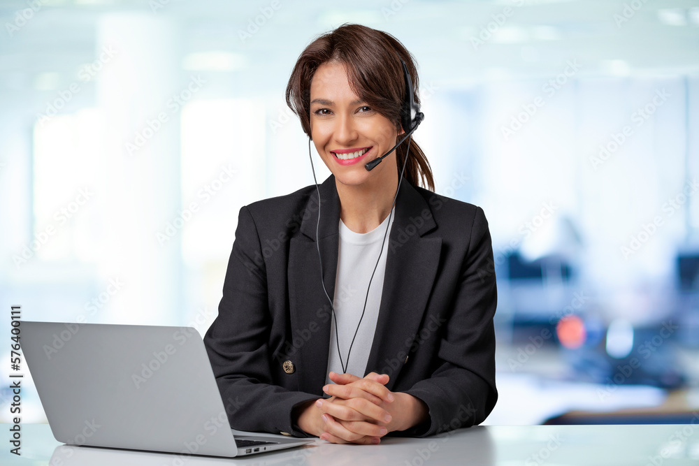 Attractive and smiling woman sitting with laptop and having online meeting Attractive and smiling woman sitting with laptop and having online meeting