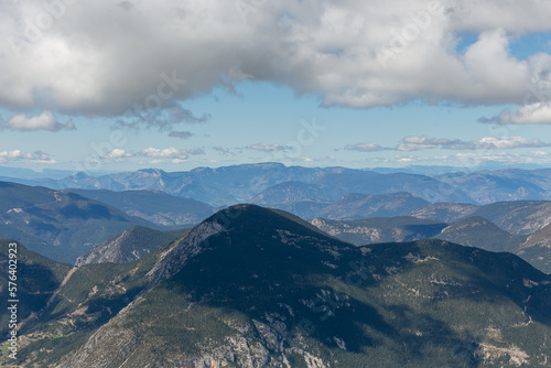 Paisaje montañoso con nubes y sol y prados en sombra