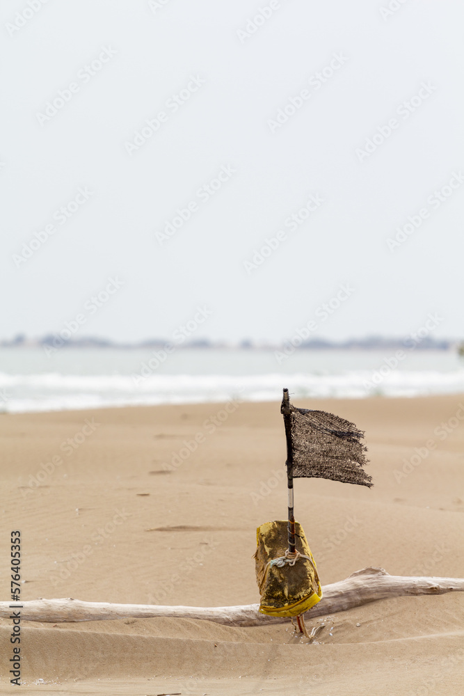 Obraz premium Bandera vieja e irreconocible ondeando en la playa con viento