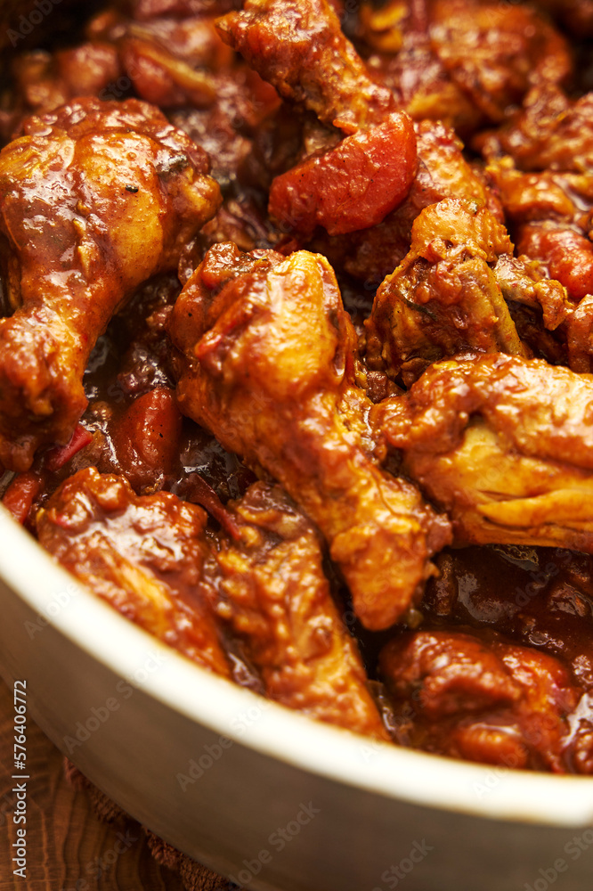 East styled Stewed chicken wings in a pot in red gravy sauce with tomatoes chilies onions and paprika. Ginger and turmeric powder plus garlic and peppers East styled Stewed chicken wings in a pot in red gravy sauce with tomatoes chilies onions and paprika. Ginger and turmeric powder plus garlic and peppers