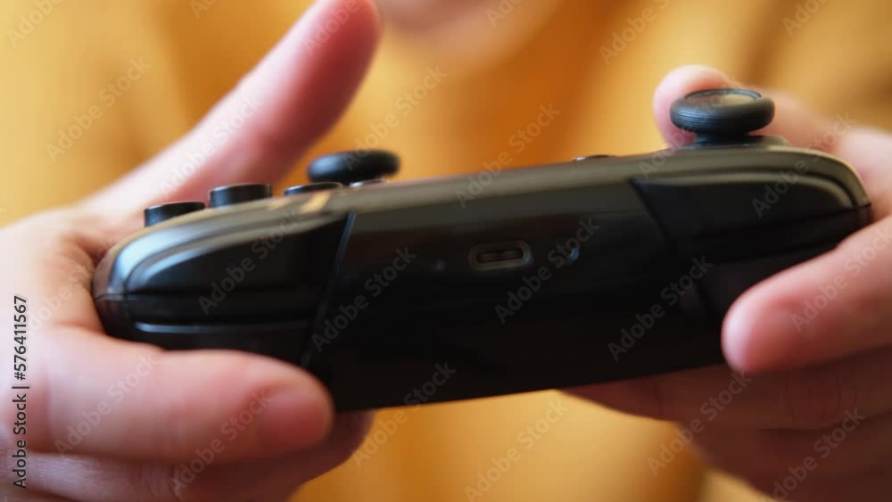 Woman hands holding black joystick gamepad playing game console. Computer gaming competition videogame control concept. Using controller playing video games. Cyberspace symbol. Hands joypad close up Woman hands holding black joystick gamepad playing game console. Computer gaming competition videogame control concept. Using controller playing video games. Cyberspace symbol. Hands joypad close up