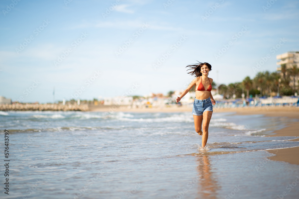 Carefree young woman running on the beach