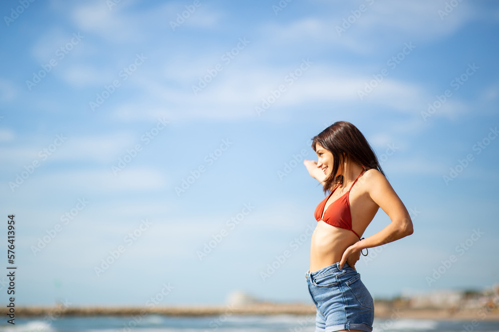 Attractive young woman standing on beach during vacation Attractive young woman standing on beach during vacation