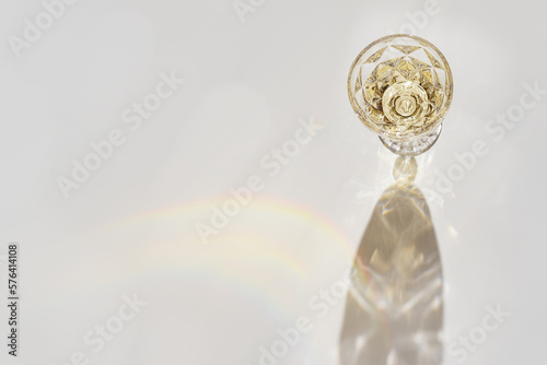 White wine in crystal transparent fashion glass with shadow and glare at sunlight, light white gray background, creative summer rest alcohol drink minimal concept, copy space, top view