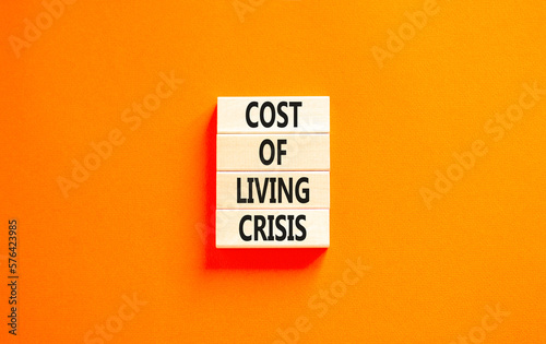 Cost of living crisis symbol. Concept words Cost of living crisis on wooden blocks. Beautiful orange table orange background. Business cost of living crisis concept. Copy space.