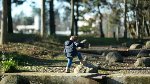 Photography Carefree child climbing stones and jumping outside in city park