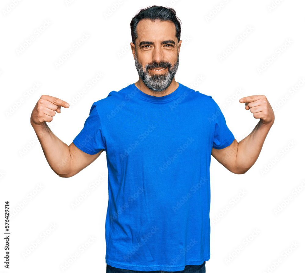 Middle aged man with beard wearing casual blue t shirt looking confident with smile on face, pointing oneself with fingers proud and happy. Middle aged man with beard wearing casual blue t shirt looking confident with smile on face, pointing oneself with fingers proud and happy.