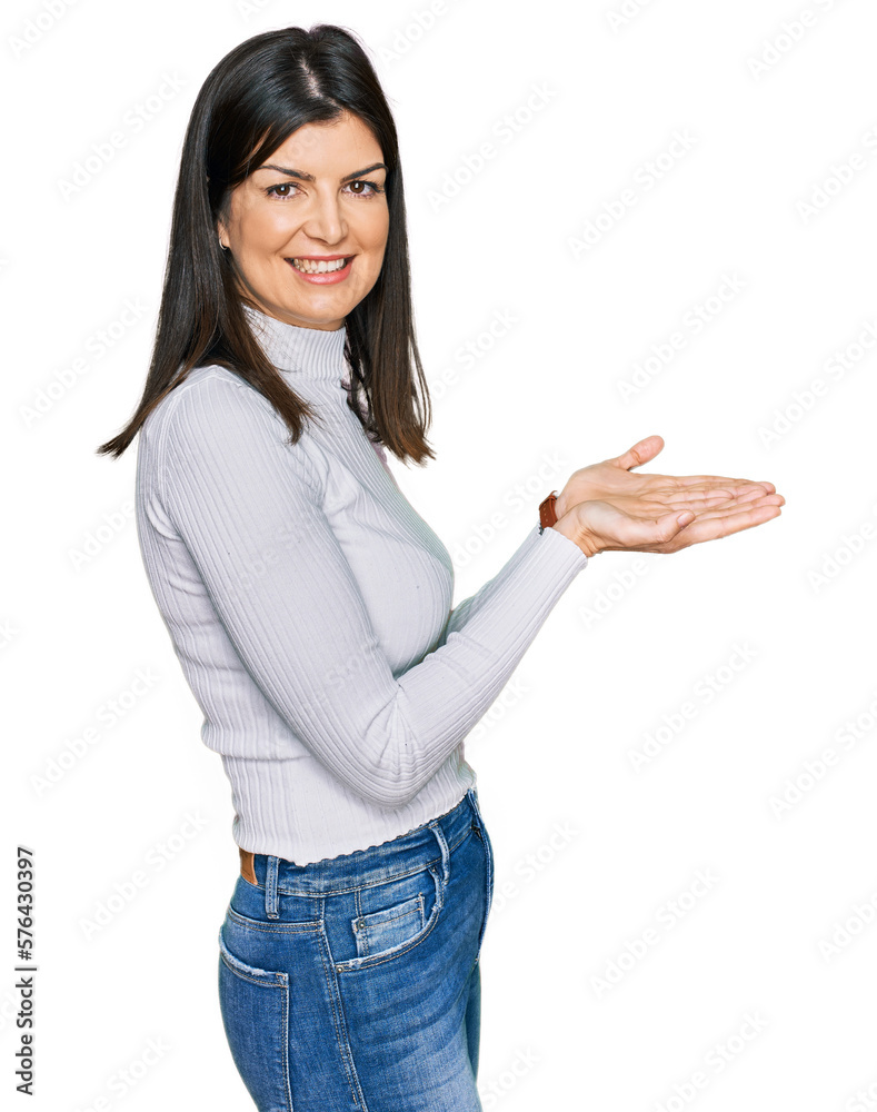 Beautiful brunette woman wearing casual clothes pointing aside with hands open palms showing copy space, presenting advertisement smiling excited happy Beautiful brunette woman wearing casual clothes pointing aside with hands open palms showing copy space, presenting advertisement smiling excited happy