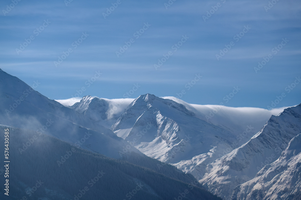 beautiful view to the snow capped alps, the hohe tauern in austria, at a sunny winter day with foehn clouds
