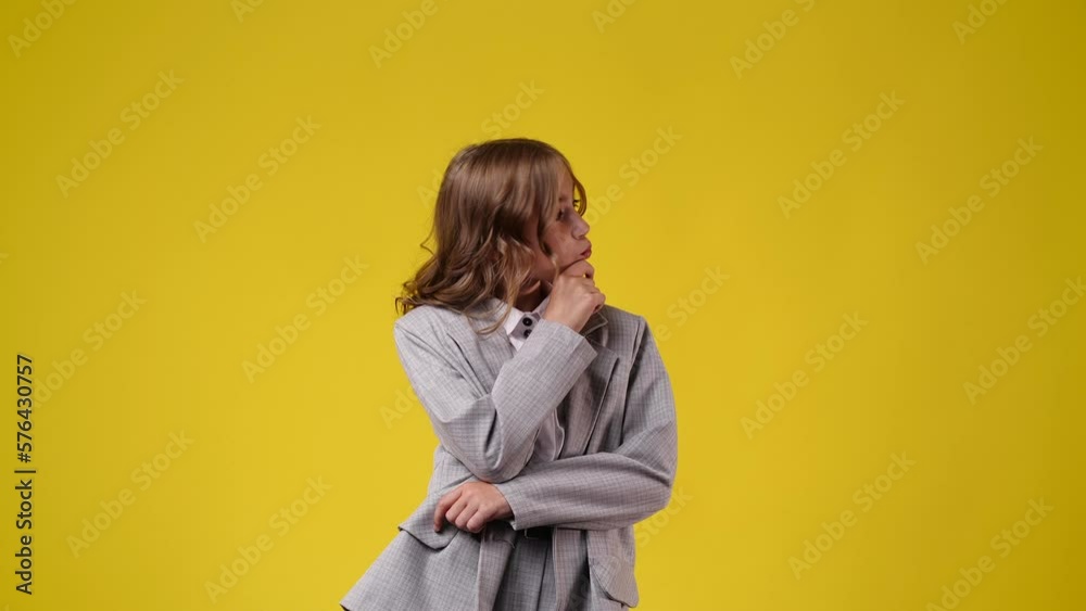 4k video of girl with thoughtful facial expression on yellow background. 4k video of girl with thoughtful facial expression on yellow background.