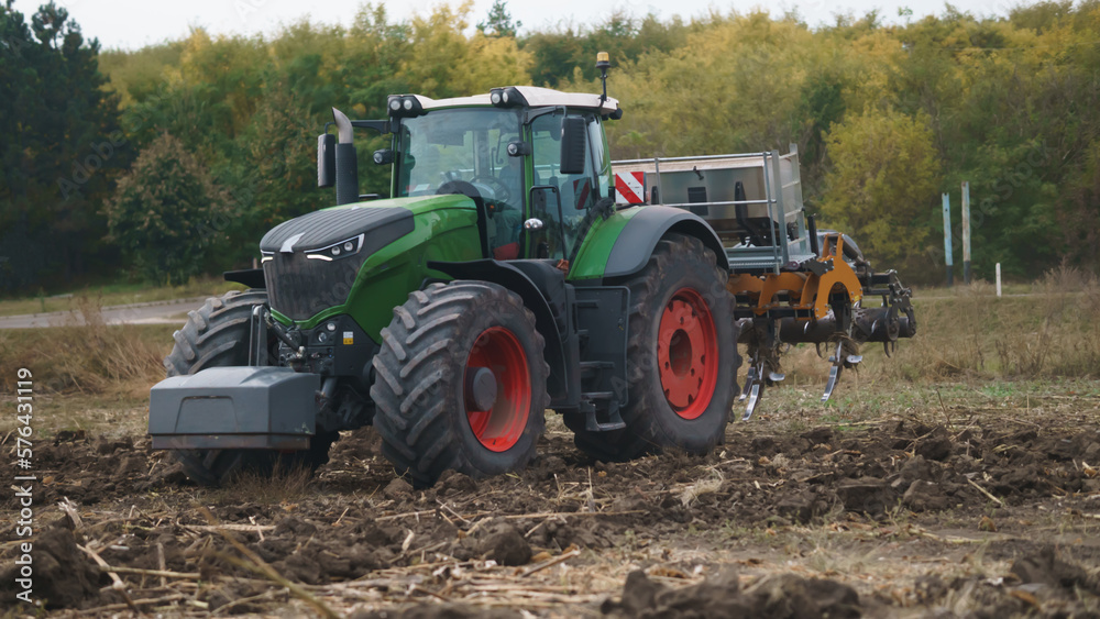 Tractor working in the field. Autumn tillage. Deep ripping with powerful tractor Tractor working in the field. Autumn tillage. Deep ripping with powerful tractor