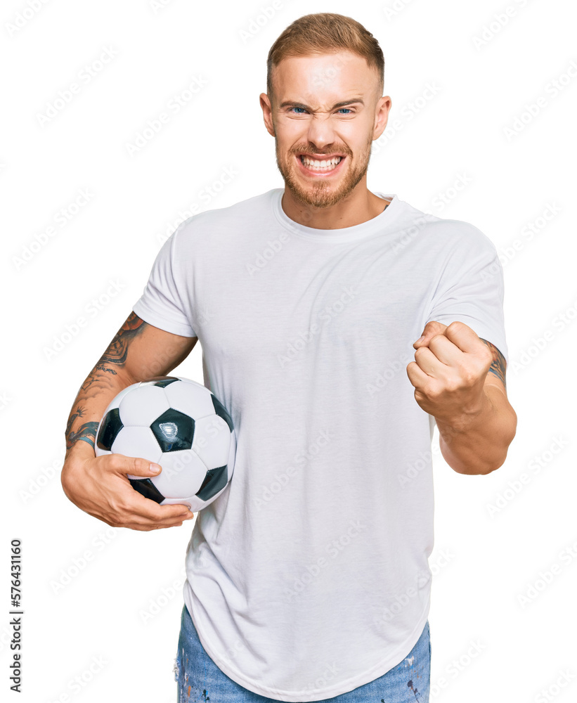 Young irish man holding soccer ball annoyed and frustrated shouting with anger, yelling crazy with anger and hand raised Young irish man holding soccer ball annoyed and frustrated shouting with anger, yelling crazy with anger and hand raised
