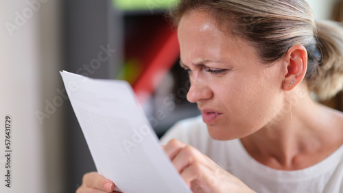 Focused female trying read text, squinting to see more clearly photo