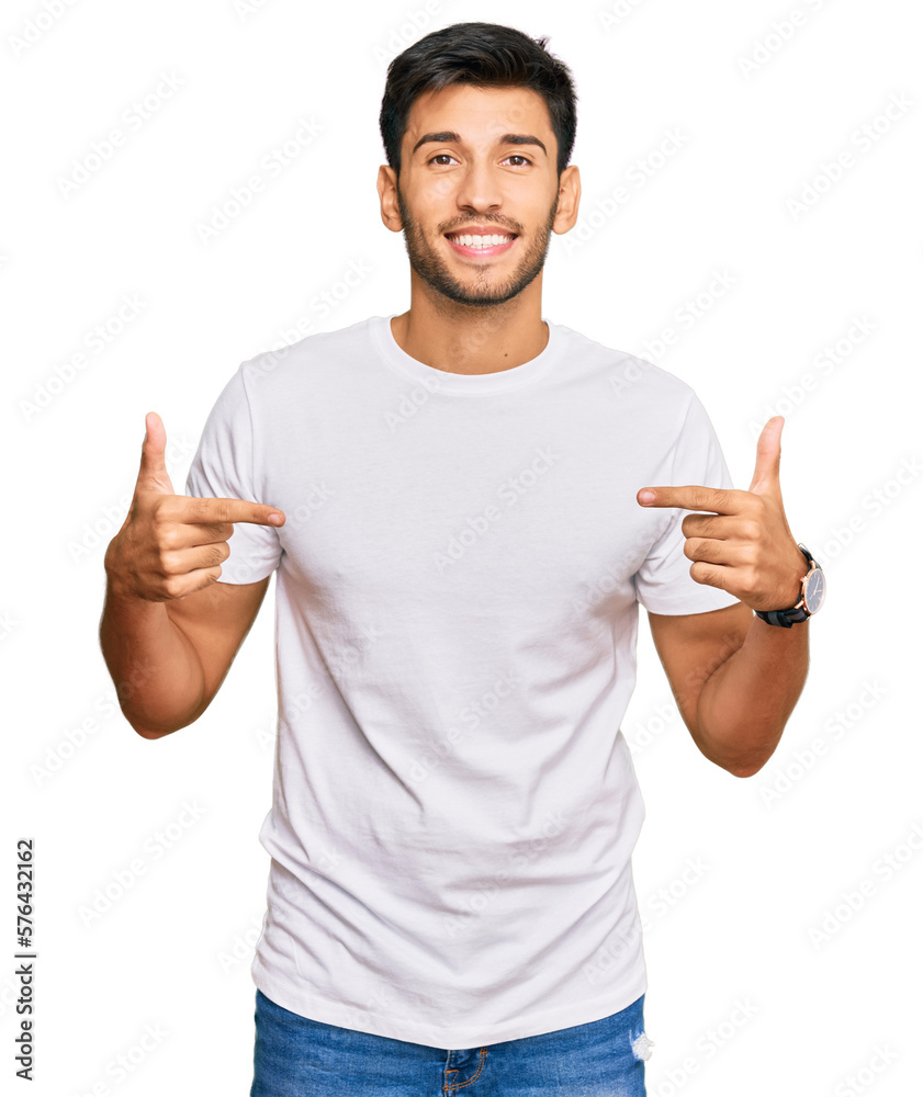 Young handsome man wearing casual white tshirt looking confident with smile on face, pointing oneself with fingers proud and happy. - obrazy, fototapety, plakaty 