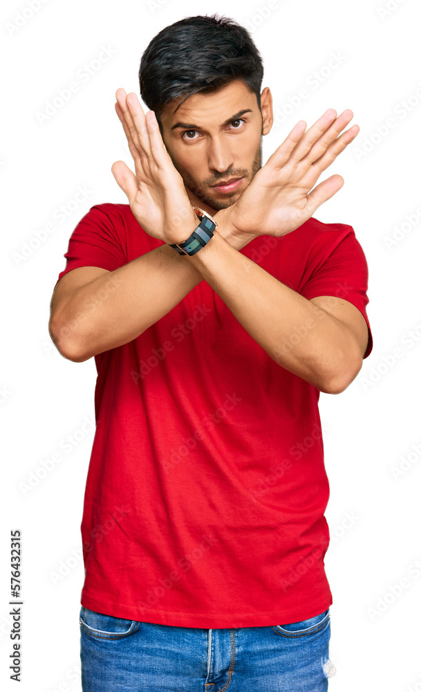Young handsome man wearing casual red tshirt rejection expression crossing arms doing negative sign, angry face Young handsome man wearing casual red tshirt rejection expression crossing arms doing negative sign, angry face