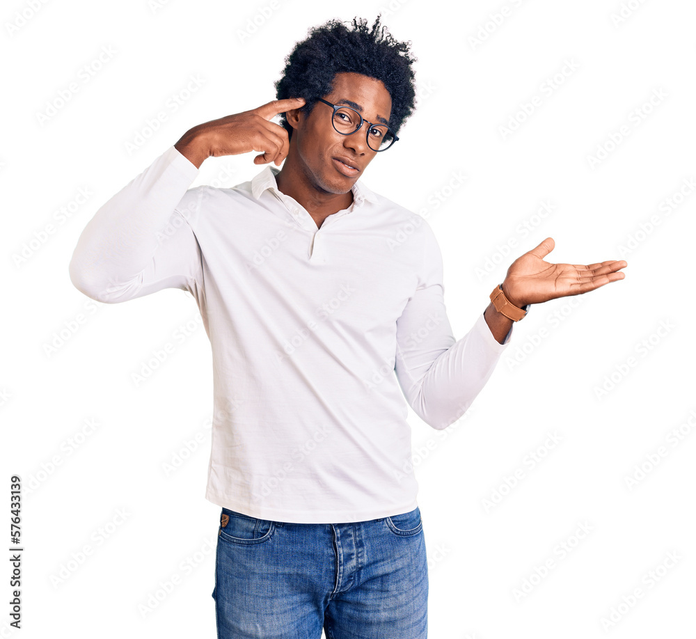 Handsome african american man with afro hair wearing casual clothes and glasses confused and annoyed with open palm showing copy space and pointing finger to forehead. think about it. Handsome african american man with afro hair wearing casual clothes and glasses confused and annoyed with open palm showing copy space and pointing finger to forehead. think about it.