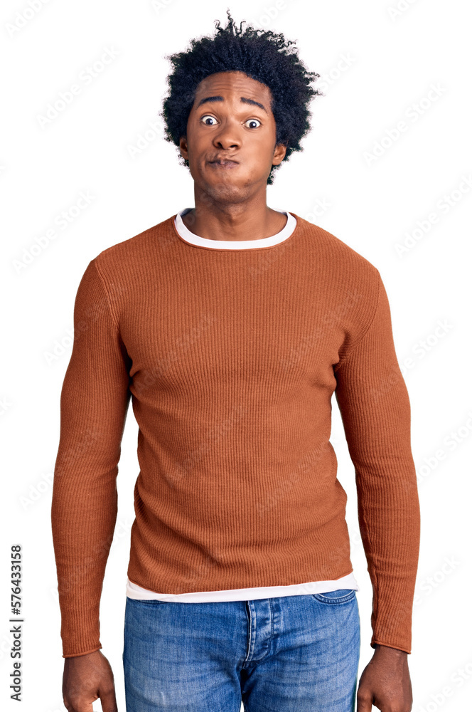 Handsome african american man with afro hair wearing casual clothes puffing cheeks with funny face. mouth inflated with air, crazy expression. Handsome african american man with afro hair wearing casual clothes puffing cheeks with funny face. mouth inflated with air, crazy expression.