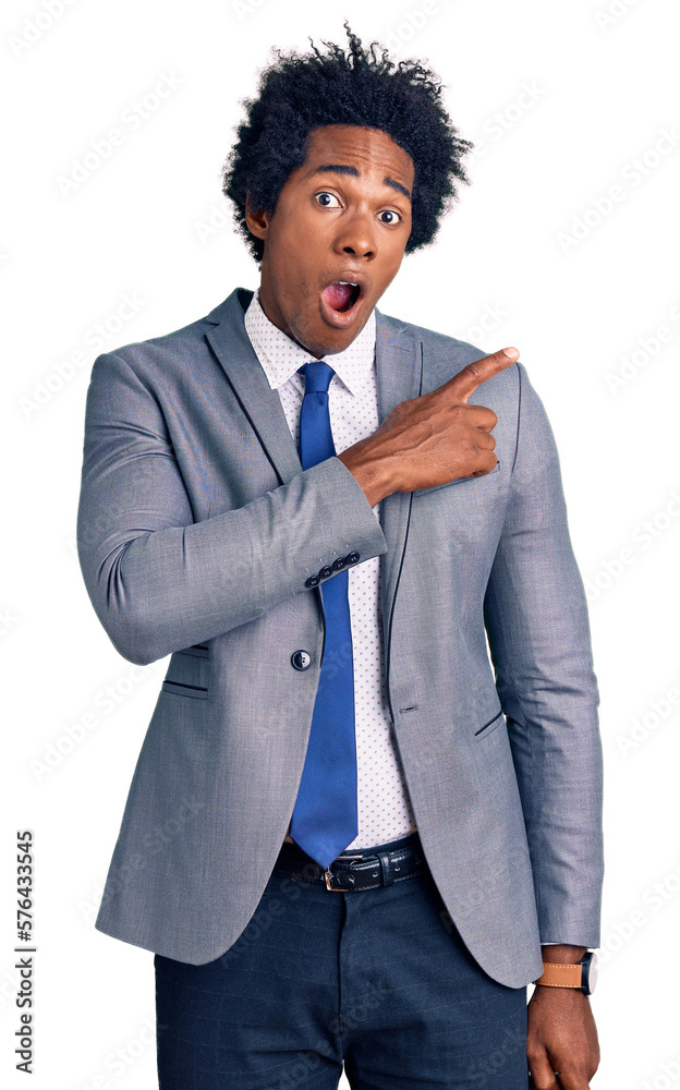 Handsome african american man with afro hair wearing business jacket surprised pointing with finger to the side, open mouth amazed expression. Handsome african american man with afro hair wearing business jacket surprised pointing with finger to the side, open mouth amazed expression.