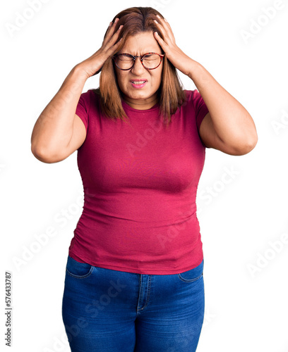 Middle age latin woman wearing casual clothes and glasses suffering from headache desperate and stressed because pain and migraine. hands on head. © Krakenimages.com