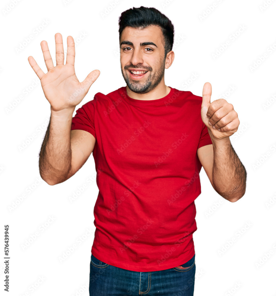 Hispanic man with beard wearing casual red t shirt showing and pointing up with fingers number six while smiling confident and happy. Hispanic man with beard wearing casual red t shirt showing and pointing up with fingers number six while smiling confident and happy.