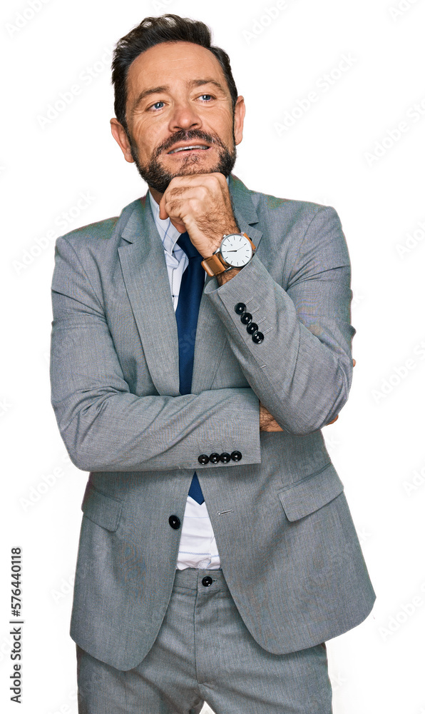 Middle age man wearing business clothes with hand on chin thinking about question, pensive expression. smiling and thoughtful face. doubt concept. Middle age man wearing business clothes with hand on chin thinking about question, pensive expression. smiling and thoughtful face. doubt concept.