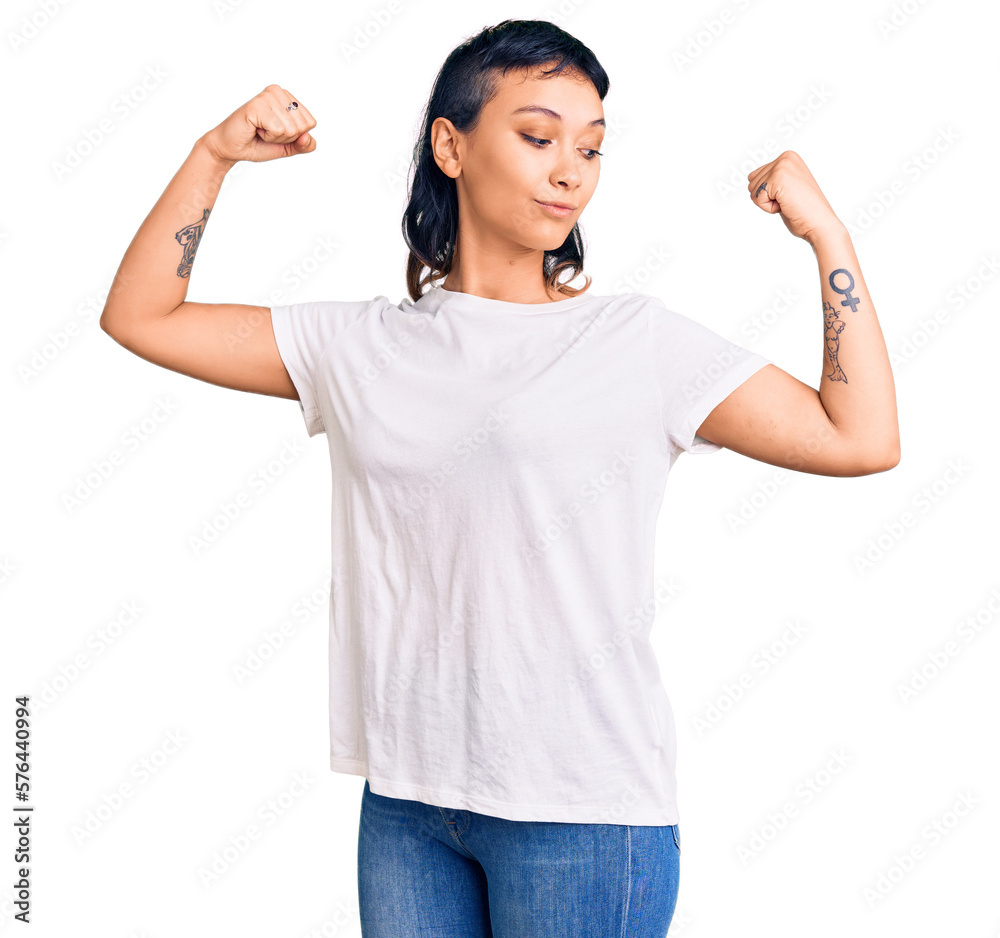 Young woman wearing casual clothes showing arms muscles smiling proud. fitness concept. Young woman wearing casual clothes showing arms muscles smiling proud. fitness concept.