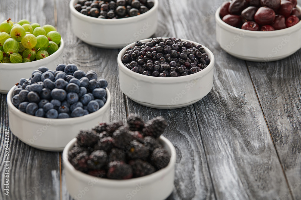 Ripe blueberries, assortment of ripe berries in bowls Ripe blueberries, assortment of ripe berries in bowls