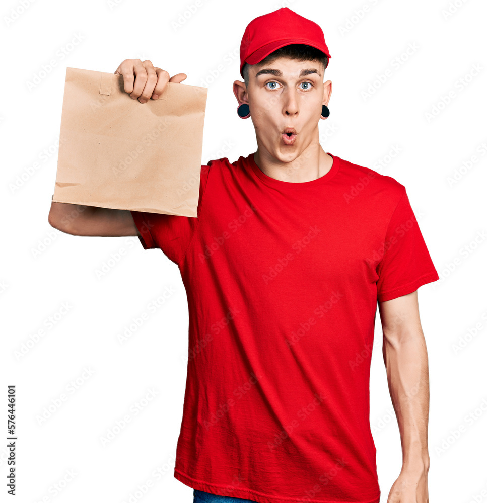 Young caucasian boy with ears dilation holding take away paper bag scared and amazed with open mouth for surprise, disbelief face Young caucasian boy with ears dilation holding take away paper bag scared and amazed with open mouth for surprise, disbelief face