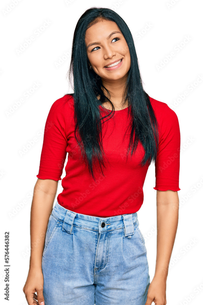 Fototapeta premium Beautiful hispanic woman wearing casual clothes looking away to side with smile on face, natural expression. laughing confident.