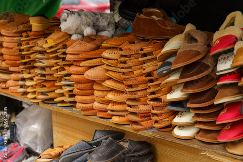 Orange light handmade leather shoes - slates and slippers at the market stalls. photo