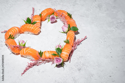 Obraz na płótnie Sushi heart with flowers on grey background. Love sushi. Salmon nigiri with blooming roses. Women's day, Valentines day and spring celebration. Romantic dinner date. Creative Japanese set. Copy space w salonie
