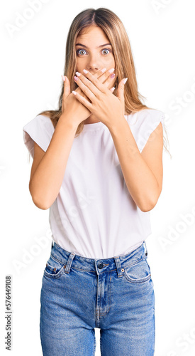 Beautiful caucasian woman with blonde hair wearing casual white tshirt shocked covering mouth with hands for mistake. secret concept.