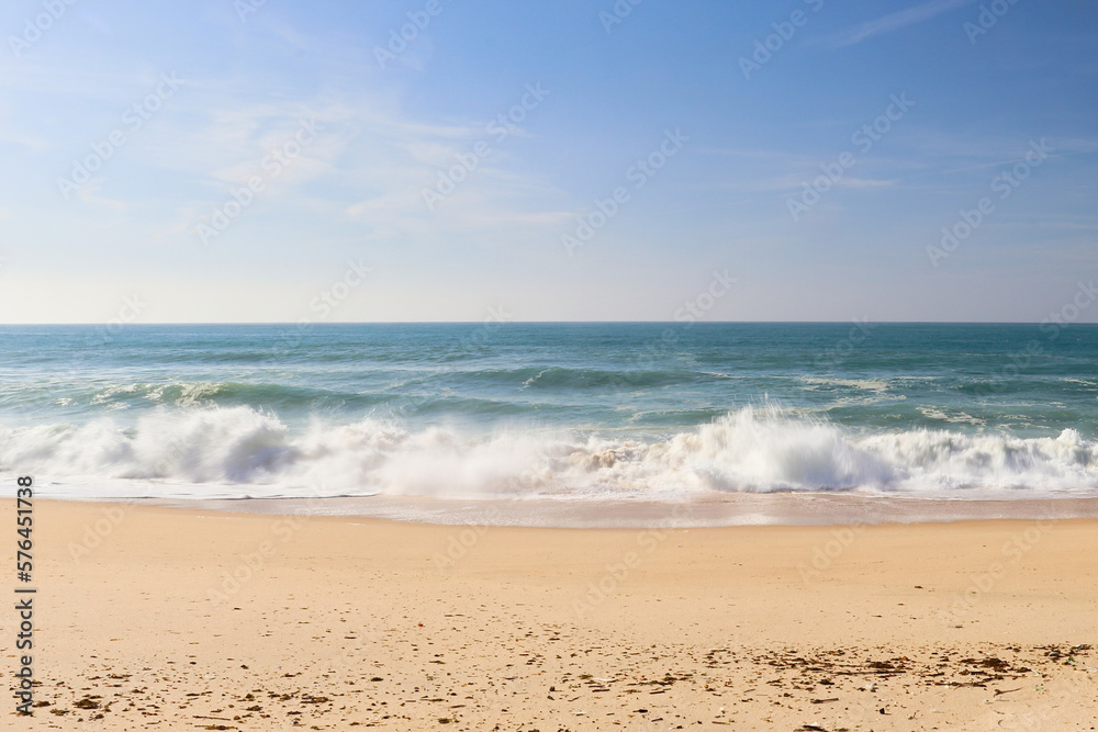 Sandy beach with waves in the ocean near Lisbon, Portugal on a sunny winter day. Sandy beach with waves in the ocean near Lisbon, Portugal on a sunny winter day.