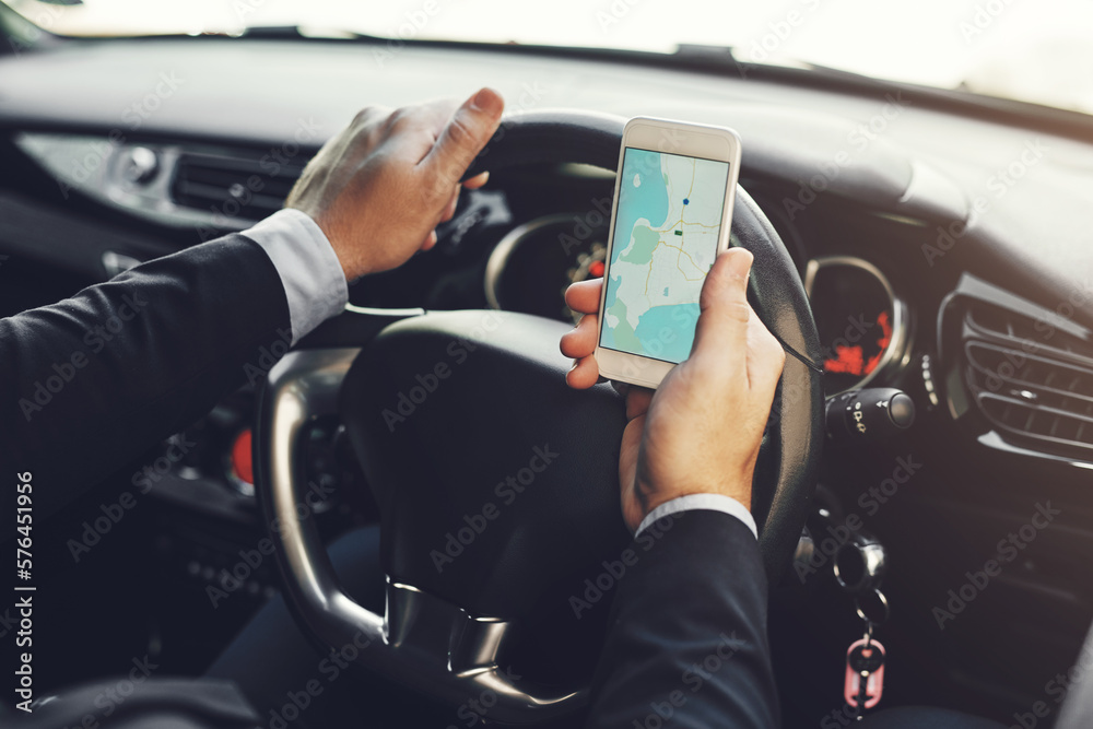 Naklejka premium Getting around with the help of technology. Closeup shot of an unrecognizable businessman using his cellphone while driving.