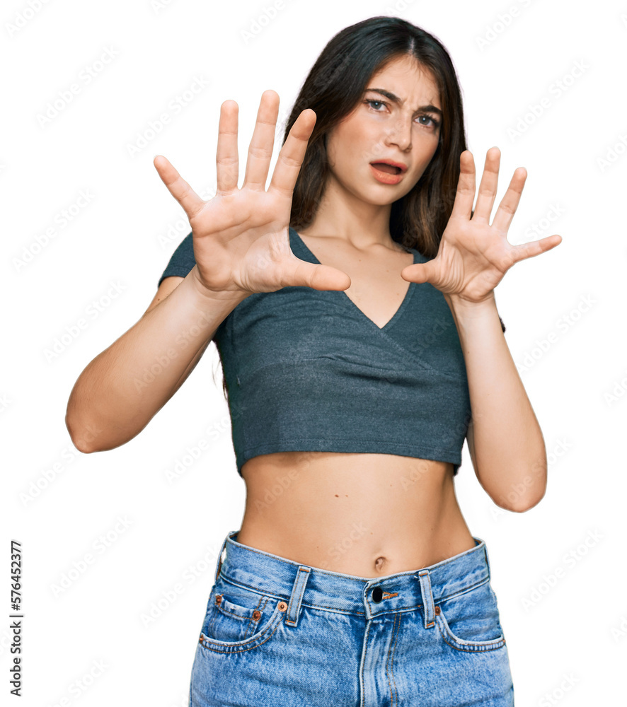 Young beautiful teen girl wearing casual crop top t shirt afraid and terrified with fear expression stop gesture with hands, shouting in shock. panic concept. Young beautiful teen girl wearing casual crop top t shirt afraid and terrified with fear expression stop gesture with hands, shouting in shock. panic concept.
