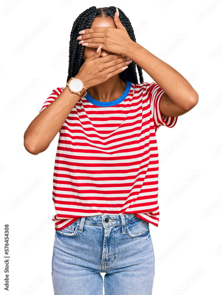 Beautiful hispanic woman wearing casual clothes covering eyes and mouth with hands, surprised and shocked. hiding emotion
