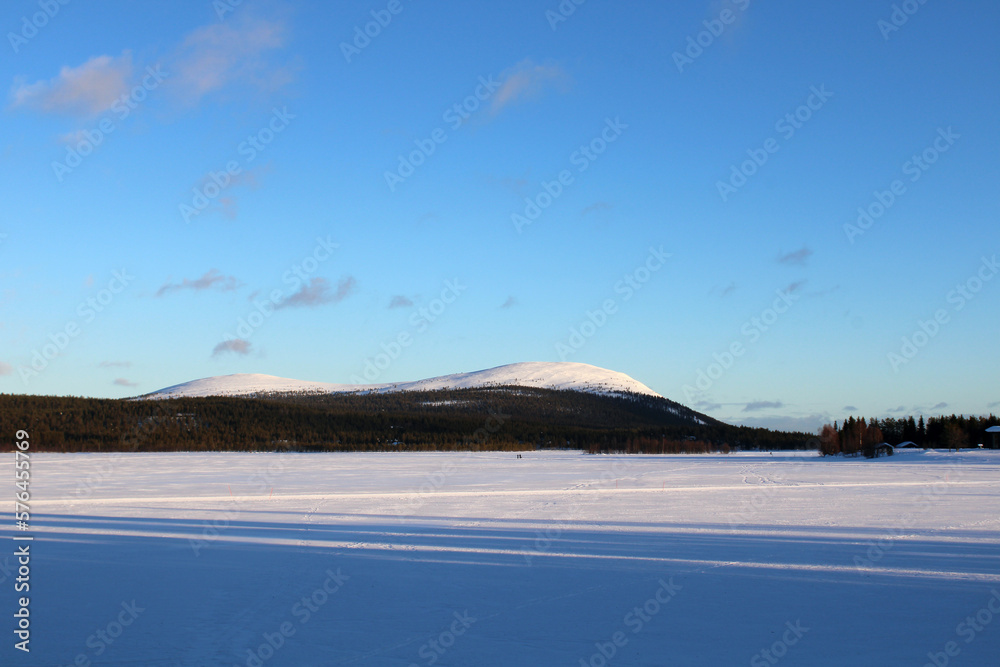 View on the surrounding hills from fhe frozen lake of Äkäslompolo, a village in Finland's Lapland region.	
