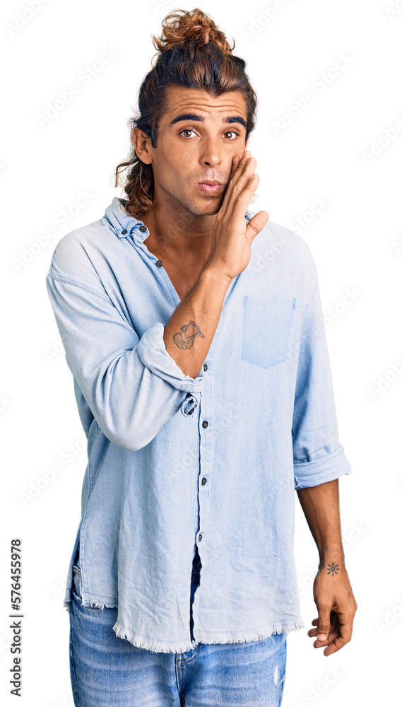 Young hispanic man wearing summer style hand on mouth telling secret rumor, whispering malicious talk conversation Young hispanic man wearing summer style hand on mouth telling secret rumor, whispering malicious talk conversation
