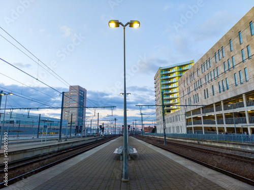 Platform 8 and 9 at Leuven, Belgium railway station with a view on the train tracks, bike parking and park inn hotel in the evening. Image taken in February.  photo