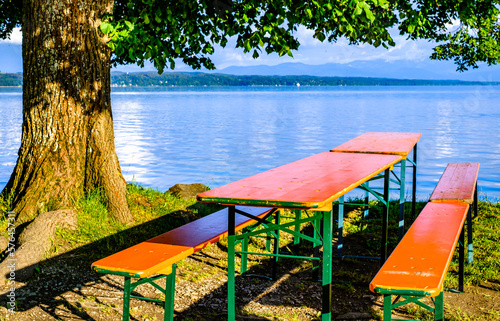 typical bavarian beergarden with wooden benches and tables photo