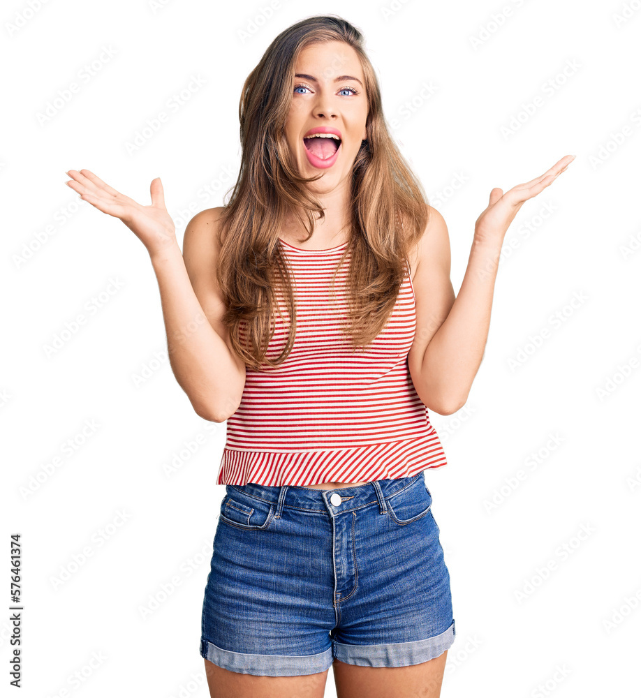 Beautiful caucasian young woman wearing casual clothes celebrating crazy and amazed for success with arms raised and open eyes screaming excited. winner concept Beautiful caucasian young woman wearing casual clothes celebrating crazy and amazed for success with arms raised and open eyes screaming excited. winner concept