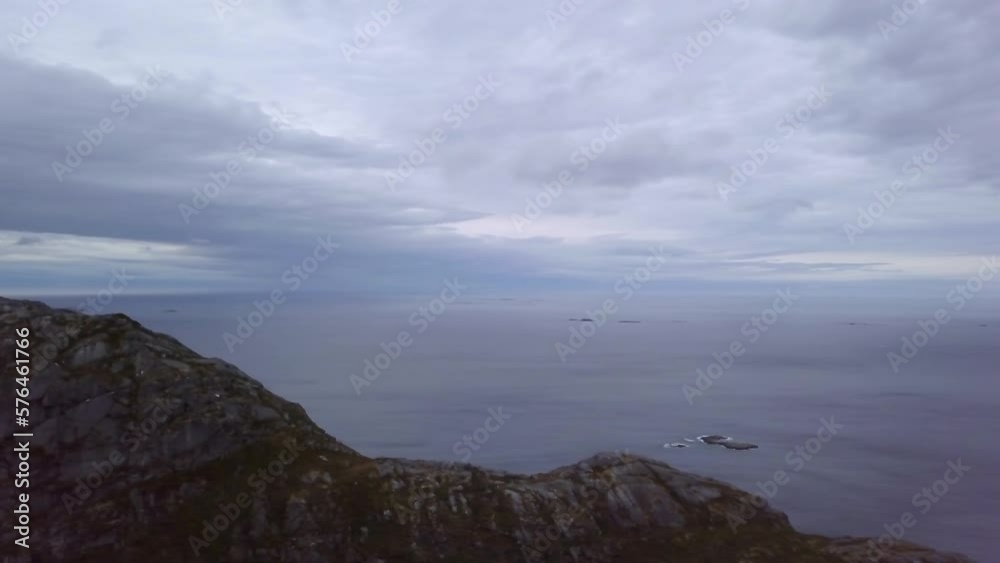 Aerial Panning Scenic Shot Of Tranquil Sea By Rock Formation Under Cloudy Sky - Tromso, Norway Aerial Panning Scenic Shot Of Tranquil Sea By Rock Formation Under Cloudy Sky - Tromso, Norway