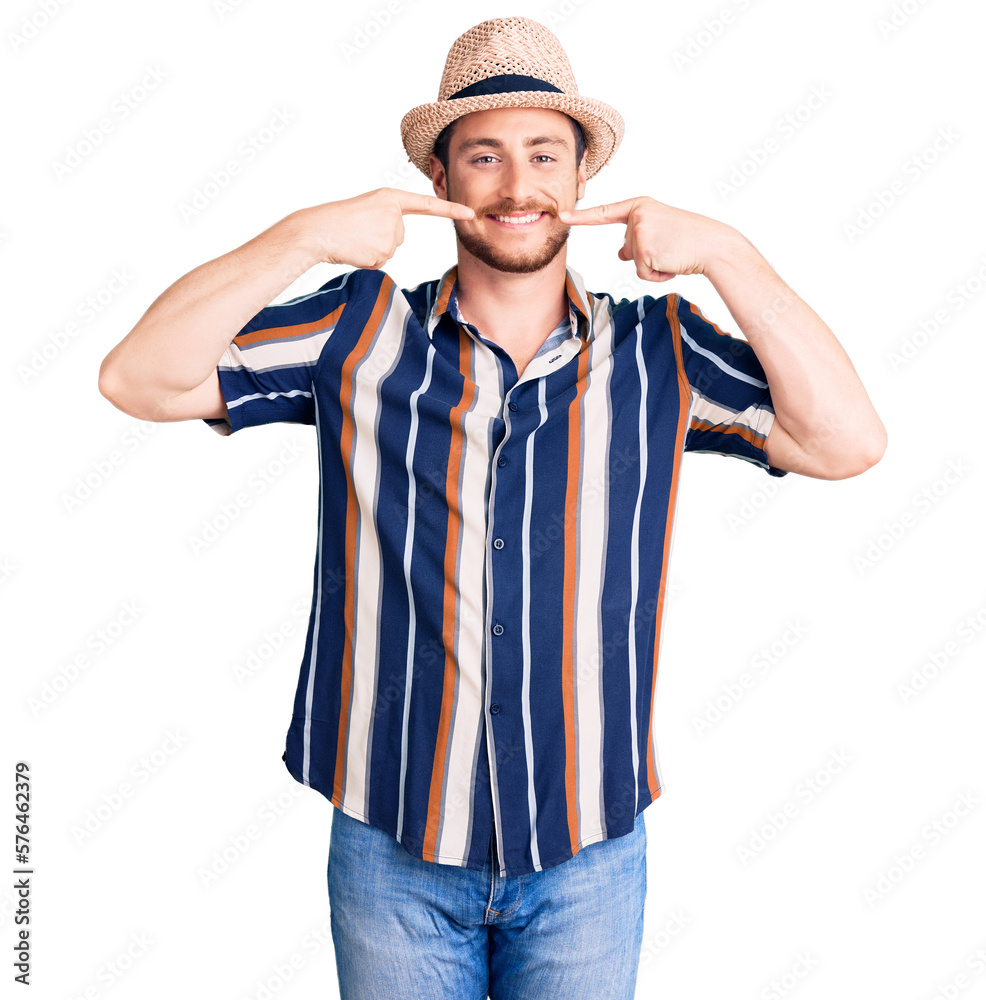 Young handsome caucasian man wearing summer hat smiling cheerful showing and pointing with fingers teeth and mouth. dental health concept. Young handsome caucasian man wearing summer hat smiling cheerful showing and pointing with fingers teeth and mouth. dental health concept.