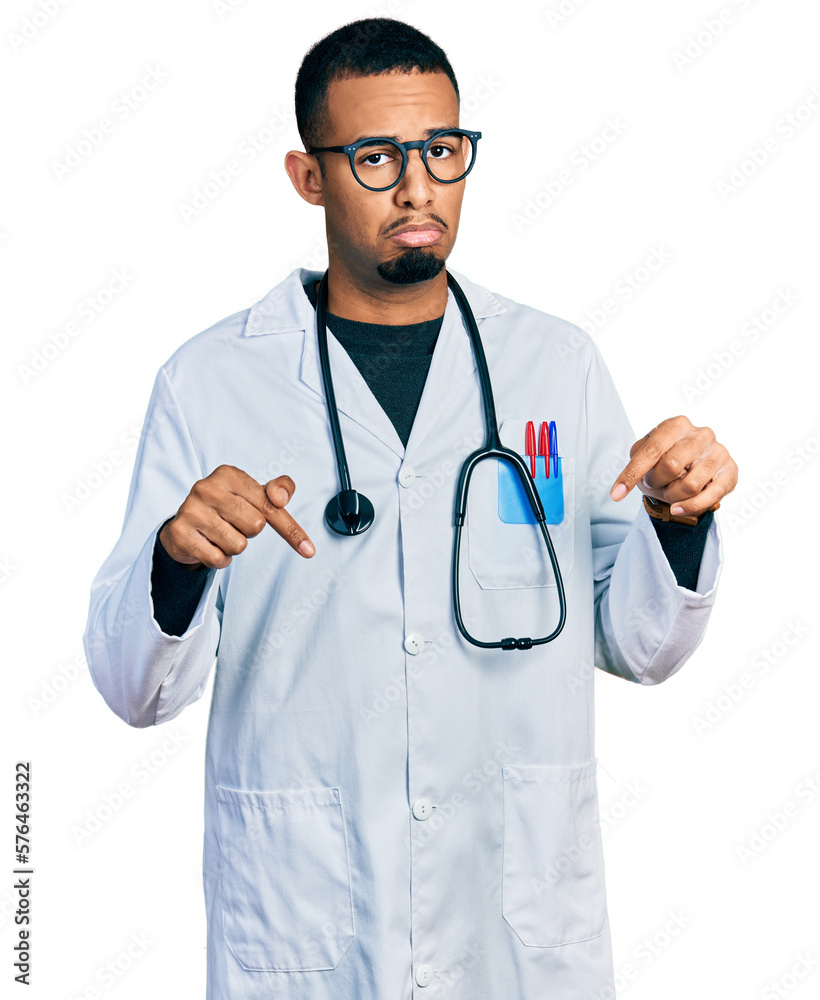 Young african american man wearing doctor uniform and stethoscope pointing down looking sad and upset, indicating direction with fingers, unhappy and depressed. Young african american man wearing doctor uniform and stethoscope pointing down looking sad and upset, indicating direction with fingers, unhappy and depressed.