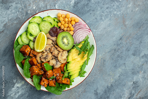 tofu, avocado, chickpeas, cucumber and mushrooms, buddha bowl. Healthy eating. Vegetarian food, place for text, top view