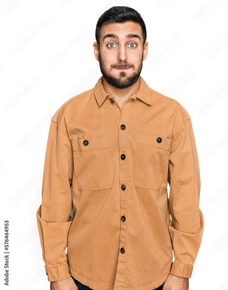 Young hispanic man wearing casual clothes puffing cheeks with funny face. mouth inflated with air, crazy expression. Young hispanic man wearing casual clothes puffing cheeks with funny face. mouth inflated with air, crazy expression.