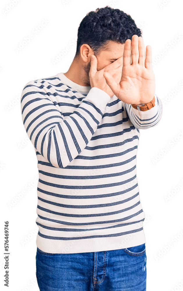 Young hispanic man wearing casual clothes covering eyes with hands and doing stop gesture with sad and fear expression. embarrassed and negative concept. Young hispanic man wearing casual clothes covering eyes with hands and doing stop gesture with sad and fear expression. embarrassed and negative concept.