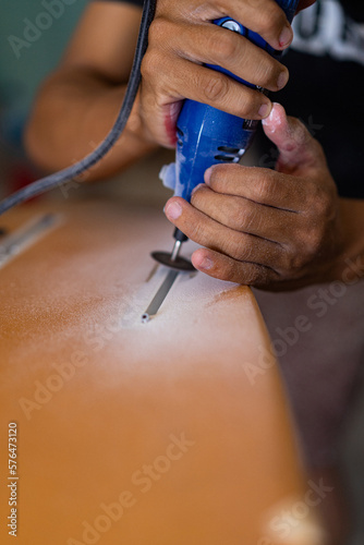 Man repairs surfboard  hands close up  Surfboard Workshop in Bali