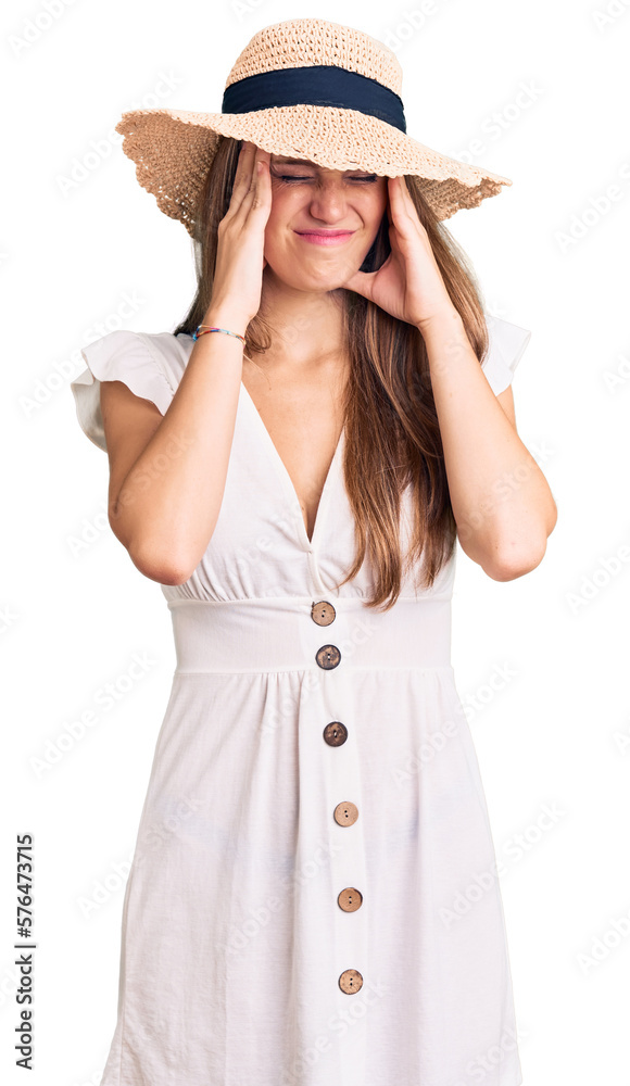 Young beautiful blonde woman wearing summer dress and hat suffering from headache desperate and stressed because pain and migraine. hands on head. Young beautiful blonde woman wearing summer dress and hat suffering from headache desperate and stressed because pain and migraine. hands on head.